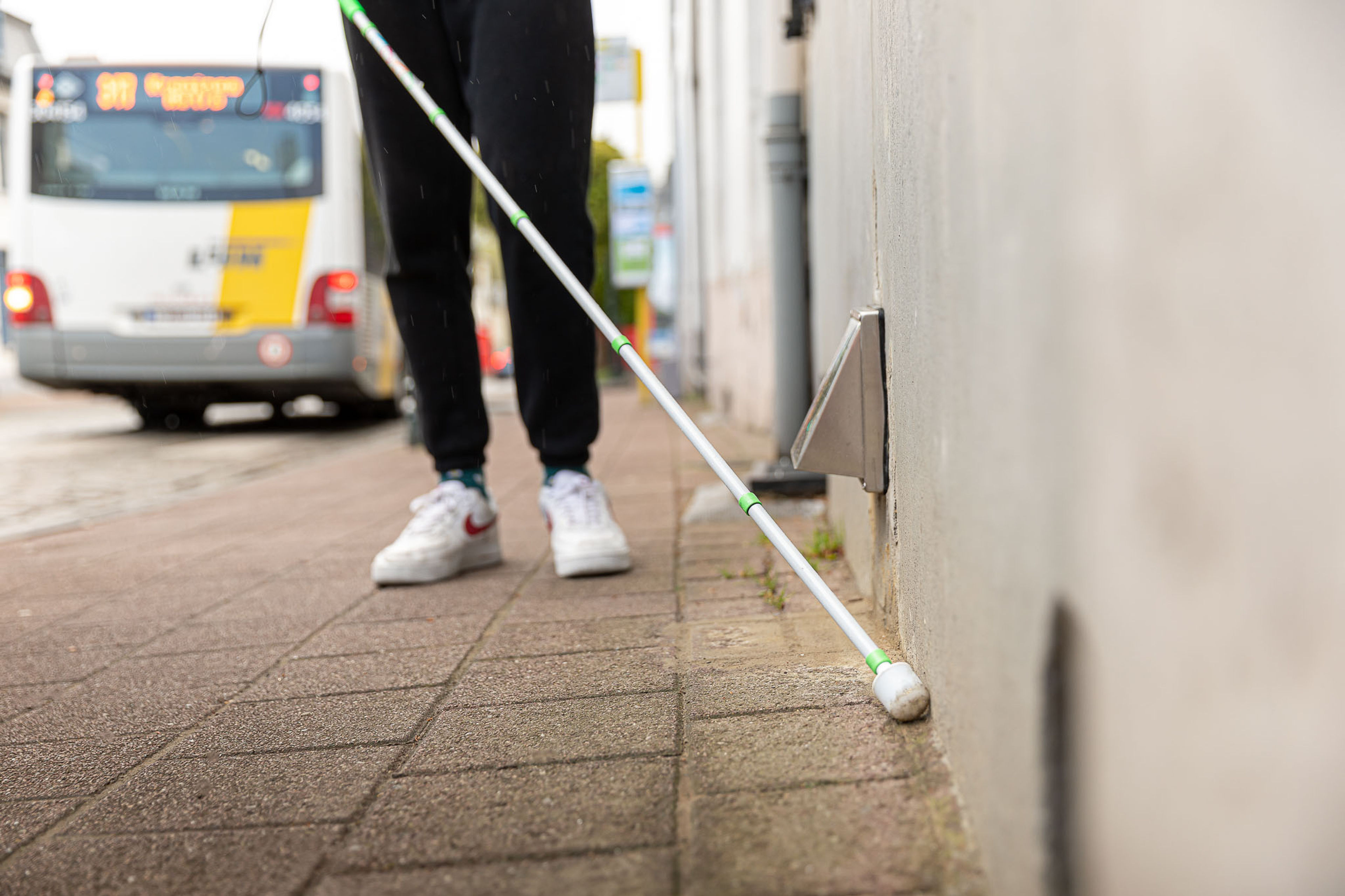 Persoon wandelt met witte stok op straat