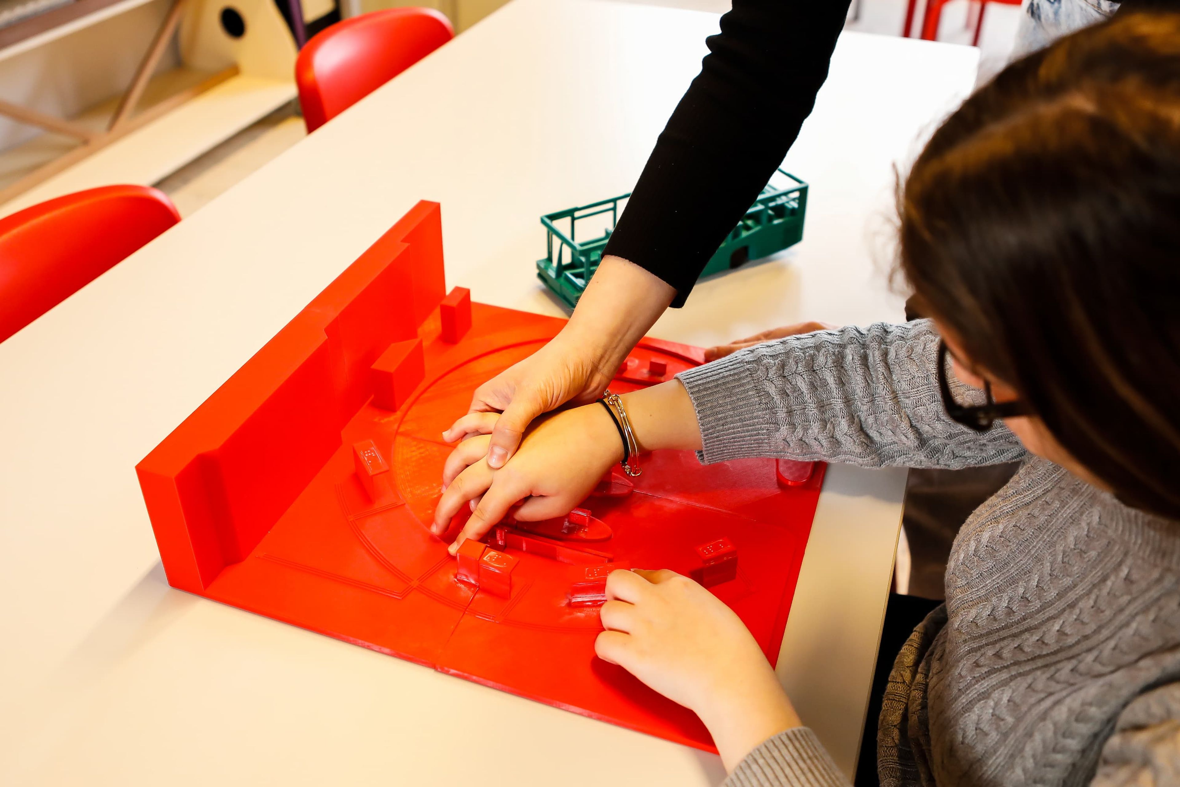 Begeleider helpt kind met leermiddelen