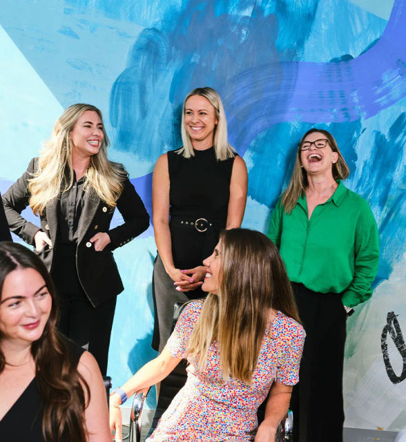 A group shot of an office team laughing