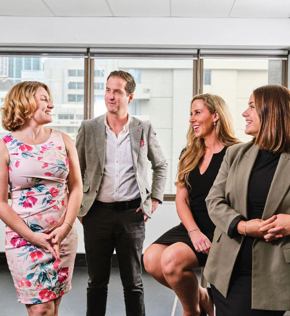 Four office staff looking happy