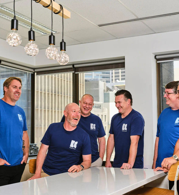 A group of people around a table laughing