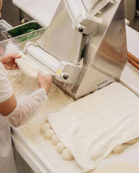 A person preparing sheets of pasta.