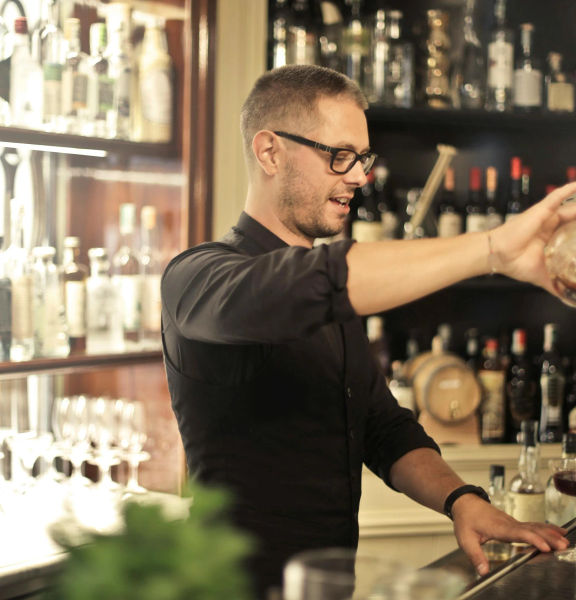 A barman pouring a cocktail.