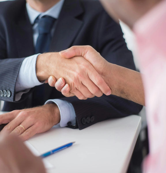 Two people in business attire shaking hands.