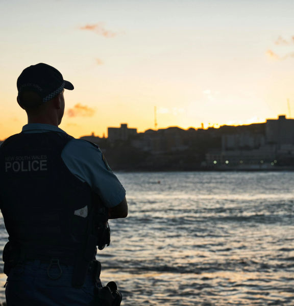 Two police officers standing beside a river.