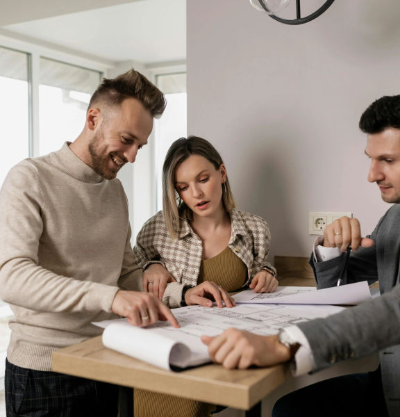Two people reviewing documents with a real estate agent.