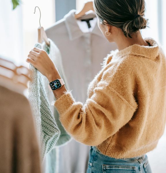 A woman selecting clothes in a retail store.