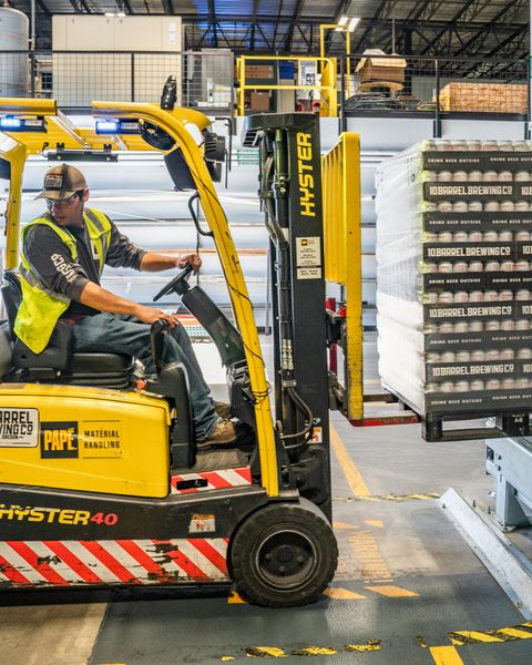 A man operating a forklift in a warehouse environment.