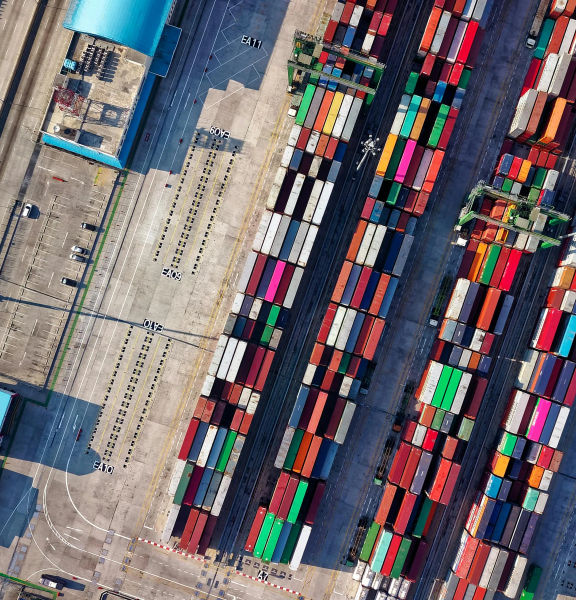 An aerial shot of a dockyard filled with shipping containers.