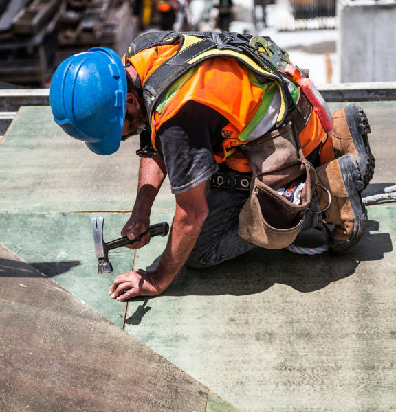 A construction worker hammering the floor.