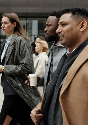 Four business people walking along a city footpath.