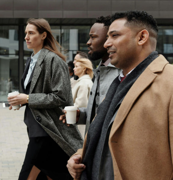 Four business people walking along a city footpath.