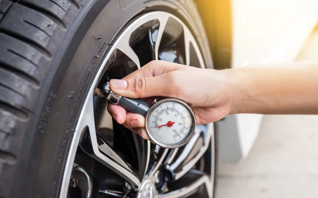 Pemeriksaan tekanan udara pada ban mobil menggunakan alat ukur digital untuk memastikan standar PSI yang tepat sebelum perjalanan jauh.
