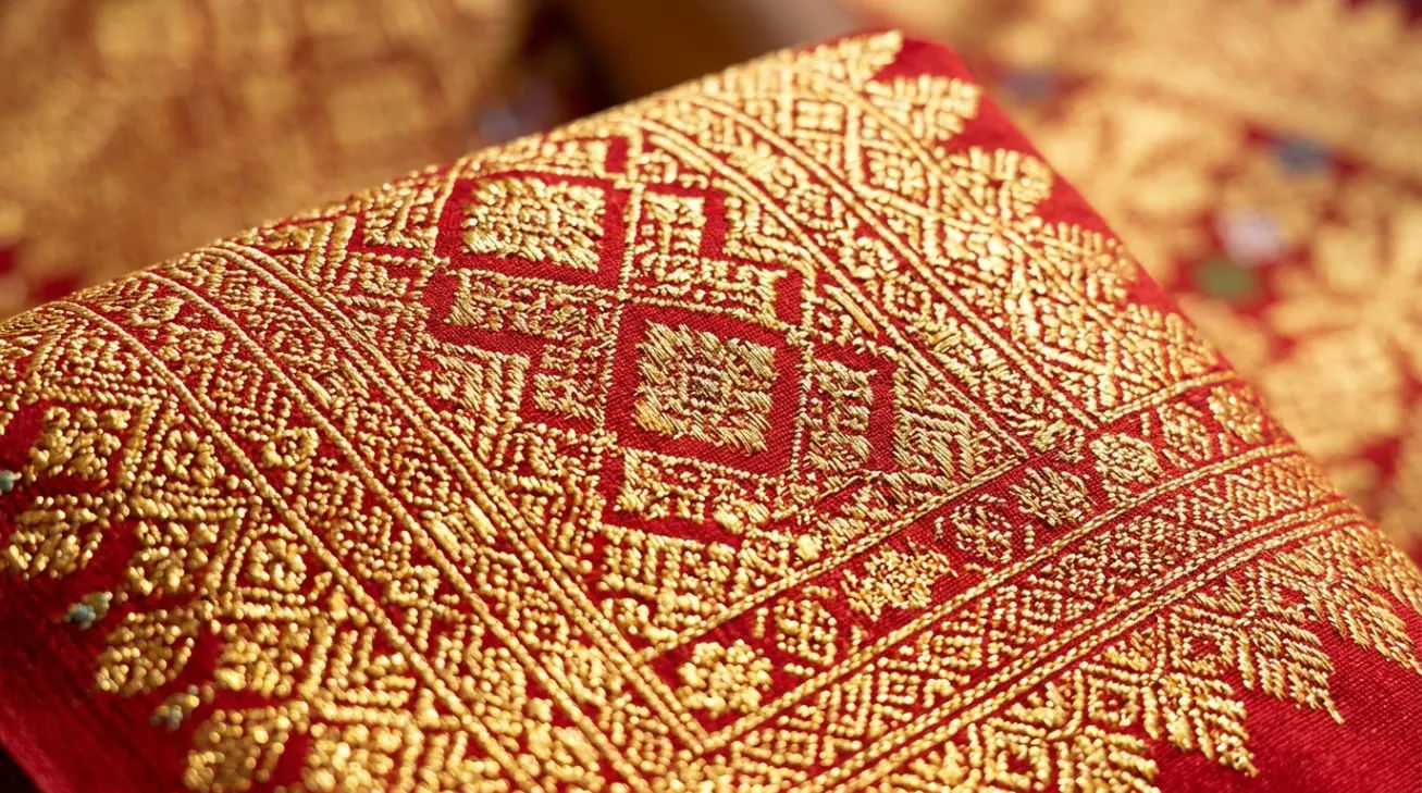 Detail tenunan benang emas pada kain songket tradisional Palembang yang menonjolkan kerapatan motif