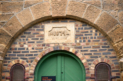 Prestongrange Museum. The image features a sturdy brick building with a detailed facade and a vibrant green door, creating an inviting entrance.