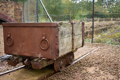 Prestongrange Museum. A neglected, rusty cart with a worn-out box stands on a track, evoking a sense of abandonment.