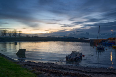 Port Seton at Night. A sleek boat glides through calm waters, its modern design evident despite the obscured details.