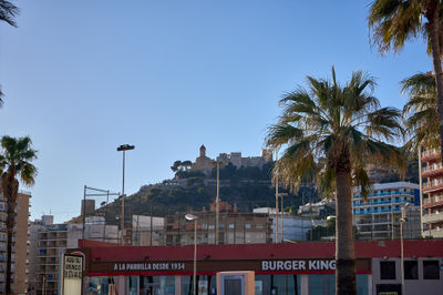 Cullera and a Castle view. A majestic castle sits atop a hill, exuding grandeur and history. Its strategic location and sturdy construction evoke power and importance.