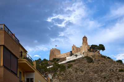 Castle of Cullera. The image depicts a beautiful building on a hill, showcasing its architectural elegance.