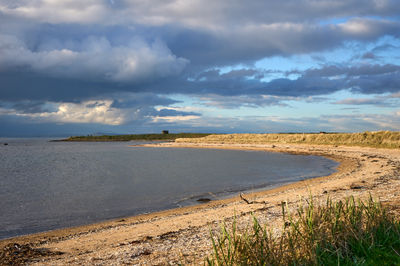 The tranquil shores of Gosford Bay in East Lothian beckon with their serene beauty and soothing waves, inviting a moment of peace in nature.