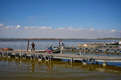In the serene beauty of Albufera, Spain, visitors savor the tranquil autumn ambiance by the calm waters, creating lasting memories.