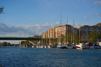 In Cullera, Spain, the autumn sun casts a warm glow over the serene marina, where boats gently sway in tranquil waters.