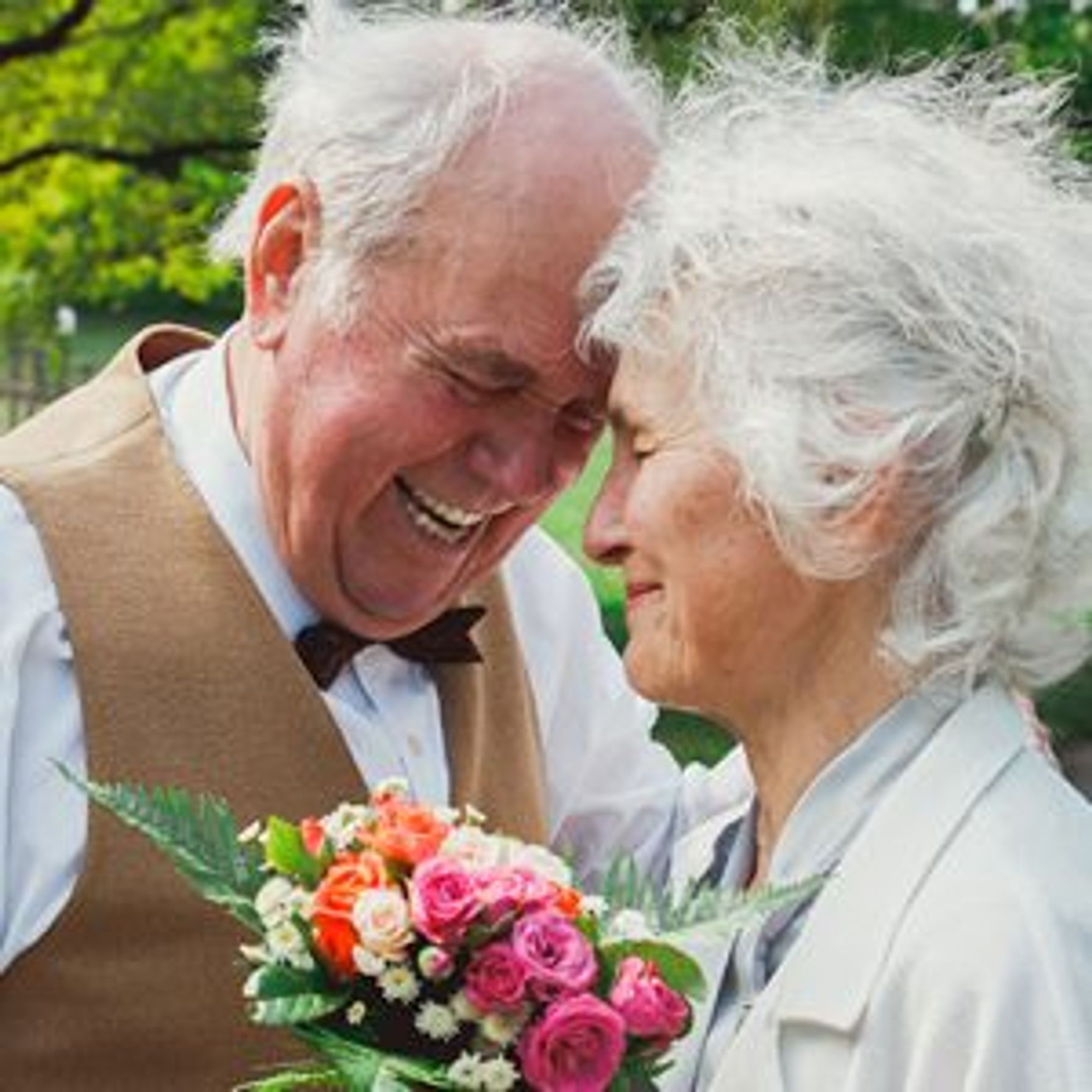 An elderly couple dressed up and smiling