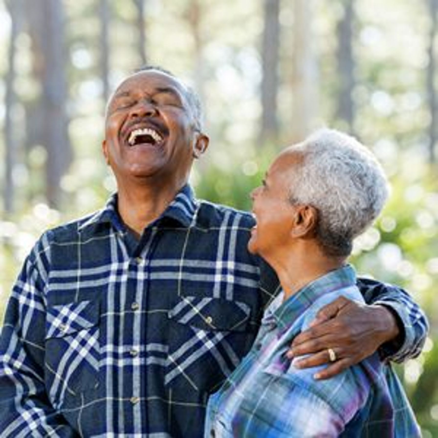 Elderly African-American couple laughing in the woods