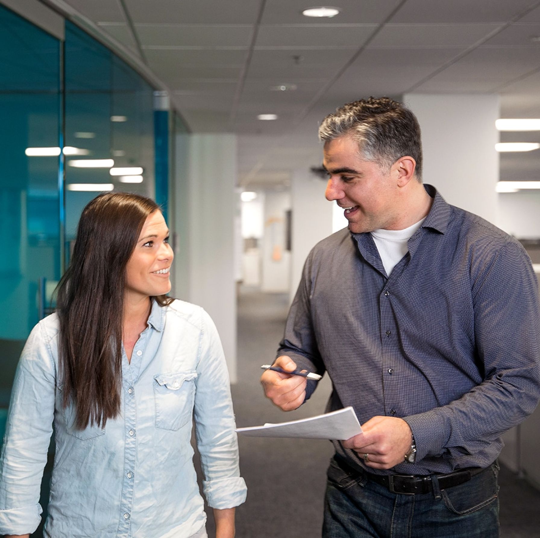 Male boss talking to a woman employee: both smiling