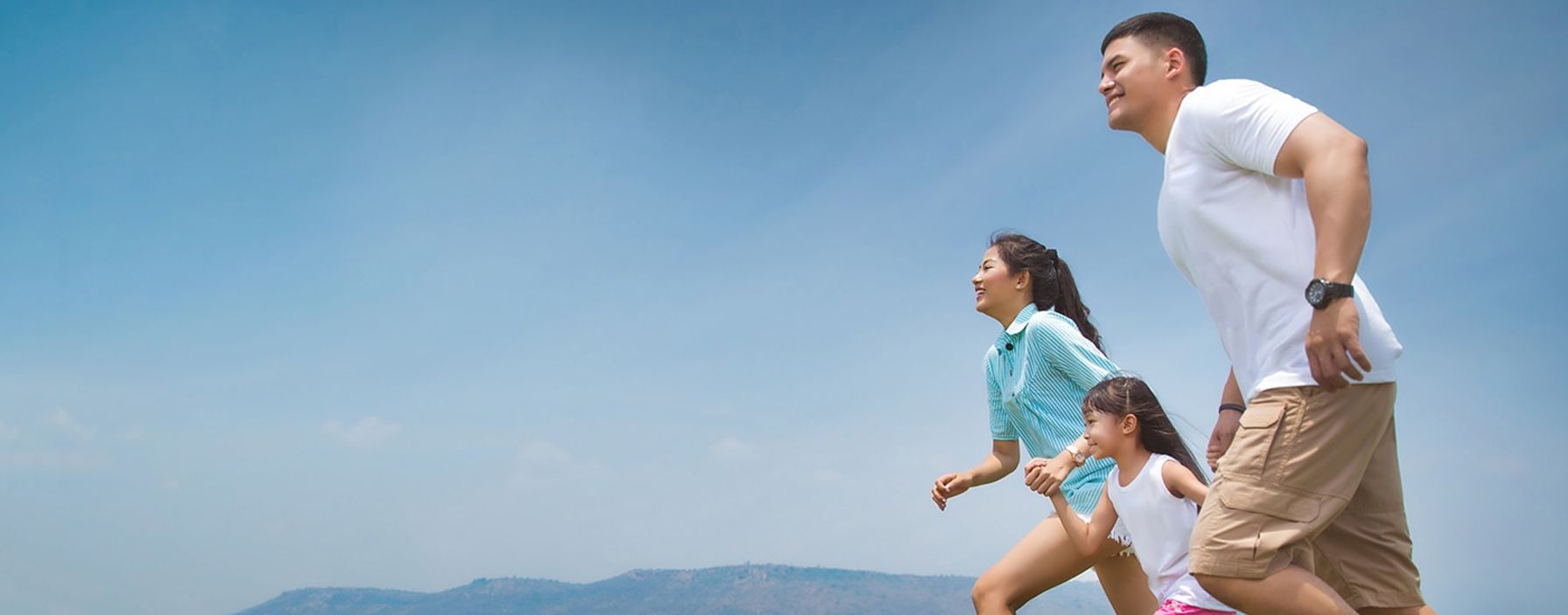 Two parents holding their daughter's hand, running outside