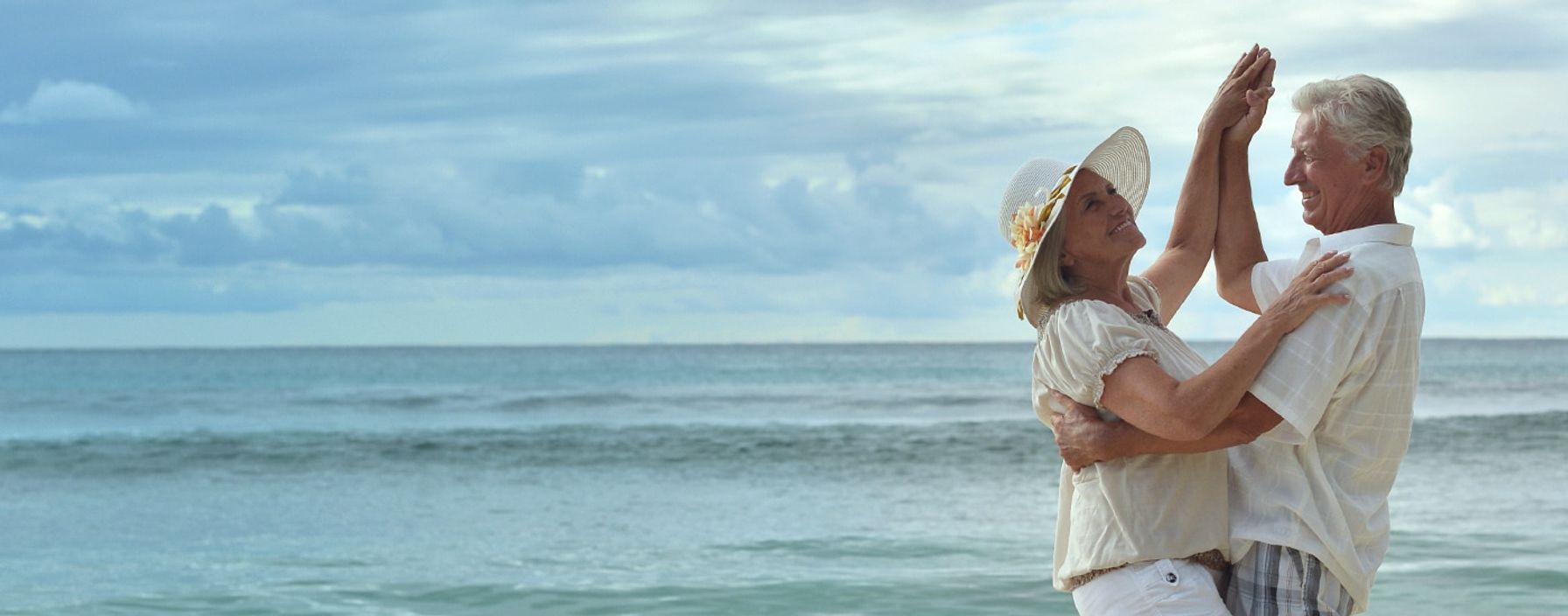 Elderly couple dancing on the beach