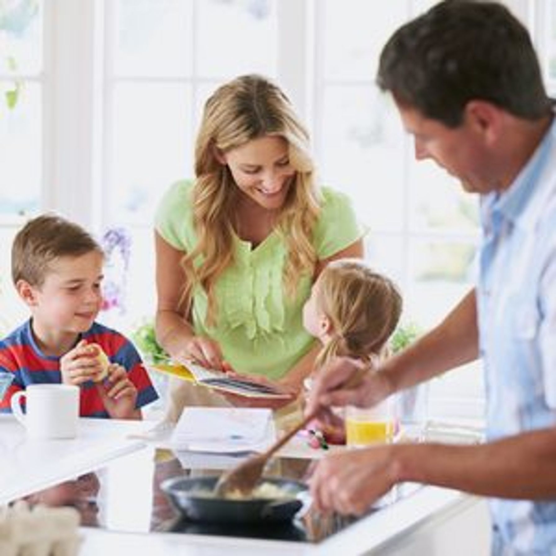 Two parents and their two kids making breakfast