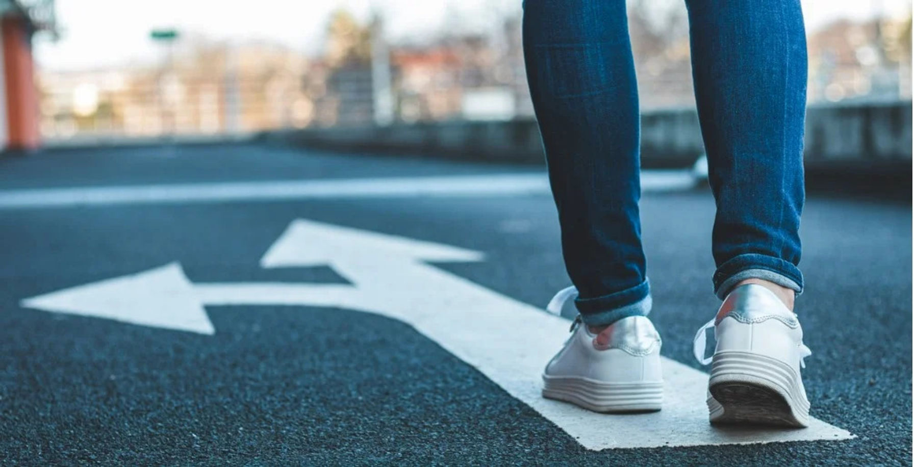 Walking on directional sign on asphalt