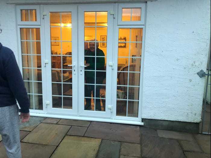 Social distancing photo gallery - an elderly speaking through a closed window