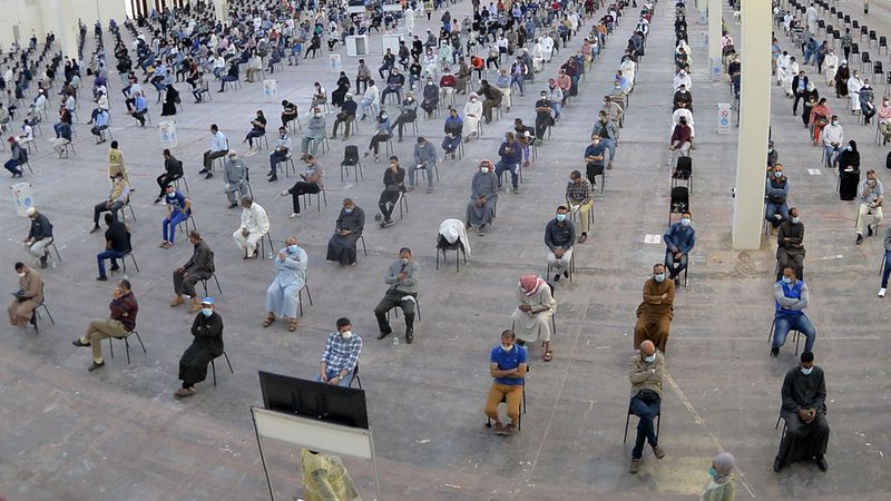 Social distancing photos - people sitting in lines waiting to be tested for Coronavirus in Kuwait