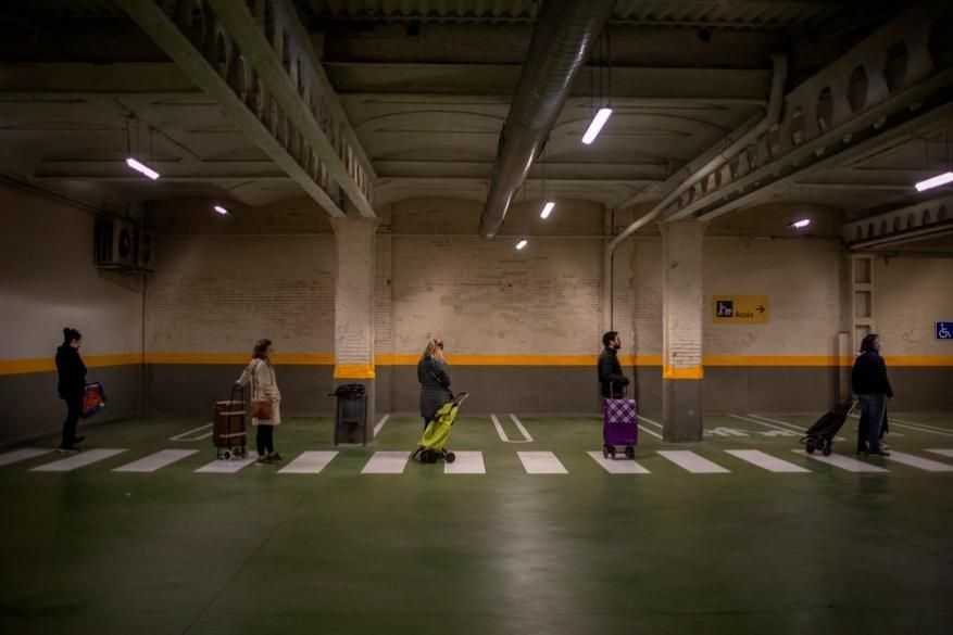Social distancing photo gallery - people queuing in parking lot in Spain
