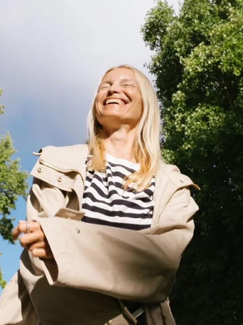Girl smiling in front of some green trees
