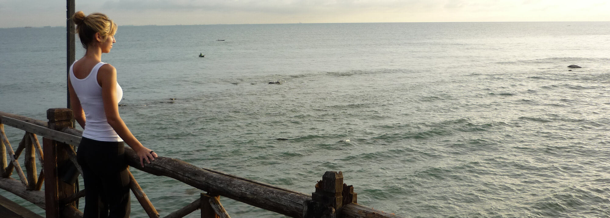 Laura from Kaleidoscope Wellness looking out from a pier in SE Asia