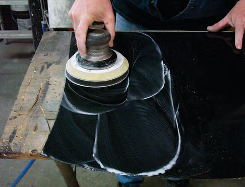 Photo 2. When you see this white slurry, you will know the sandpaper is working. The slurry is clear coat being removed from the panel. Also notice that I am using a 50% overlap with each pass of the sander.