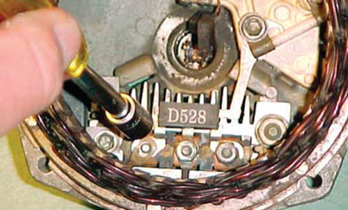 Photo 9. Removing the three nuts that secure stator winding to rectifier bridge.