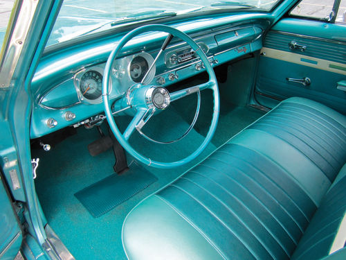 The Nova still has its original steering wheel, radio and door panels.