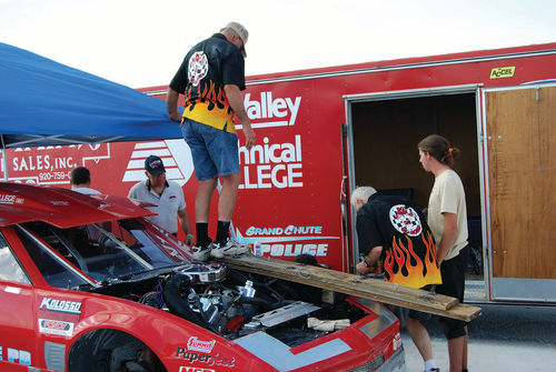 Team member Bob Buchman tried to get the left front end low enough for chaining by placing a board on the fender and standing on it but eventually it took the combined efforts of four people to weigh down the front for chaining.