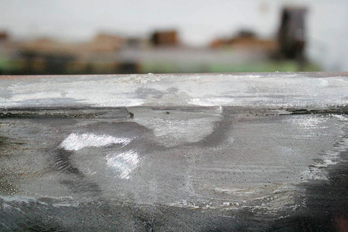 The finished lead-free solder repair covers a series of jagged gouges that I put along the bead at the top of this door with a cold chisel.