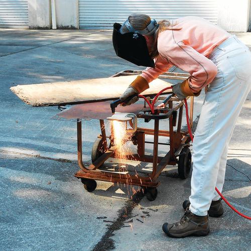 Photo 19. My wife Mary uses the plasma cutter and traces around a template of a cat’s head.