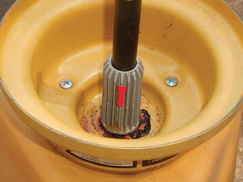 Photo 6. The dampener basin should be filled with 20-weight oil to the step on the center post (note the arrow).