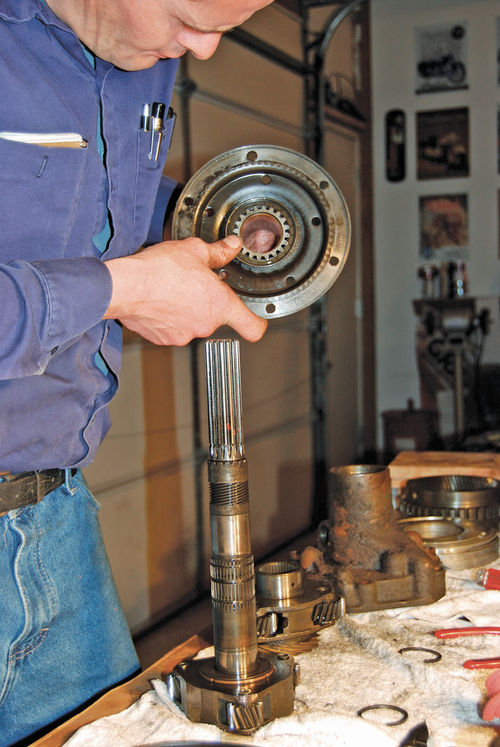 6. Vince Sauberlich inspects the reverse center gear and drive flange assembly of the reverse unit for damage or wear. Many parts have to be closely checked.