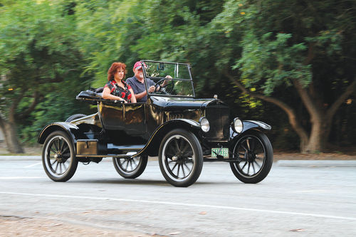 Here is where a Model T belongs — cruising along a tree-lined two-lane road.