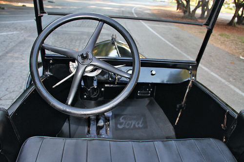 The right-hand lever behind the steering wheel is the throttle, and it has no return spring. The spark advance is to the left behind the wheel.