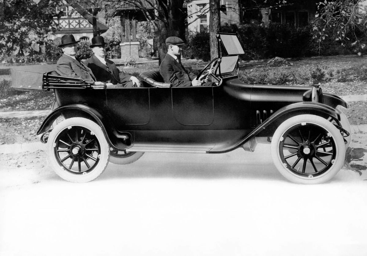 Guy Ameel, superintendent of final assembly, drives Horace and John Dodge around Detroit in their first car, Old Betsy.