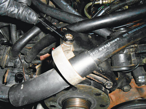 24. Remove the metal loop retaining the AC hose on the alternator bracket, and the AC compressor can be safely moved to loosen its belt.